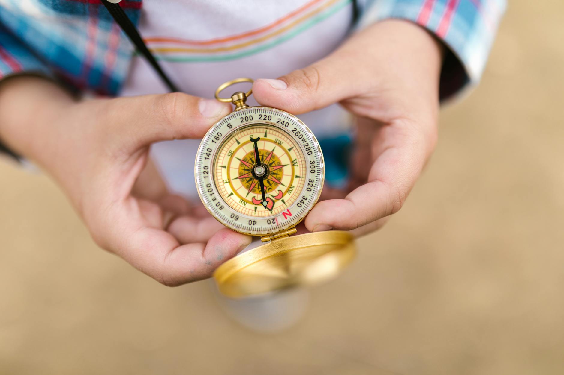 gold and silver compass on person s hand